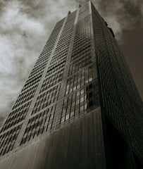 Dramatic black and white (monochrome) fine art photography print of a tall skyscraper, looking up toward the sky, titled Dystopian Dreams.