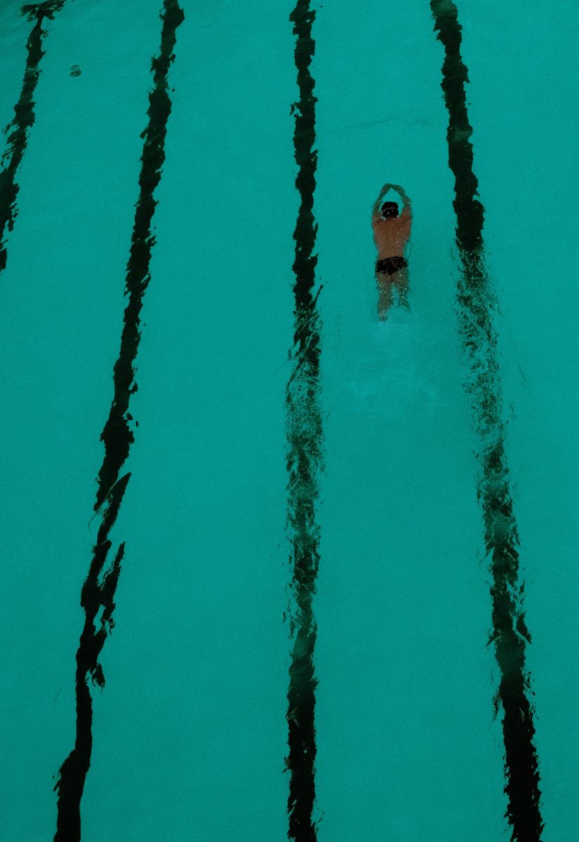 Moody, high-contrast fine art photography print of the iconic Bondi Icebergs pool with a swimmer in teal water.