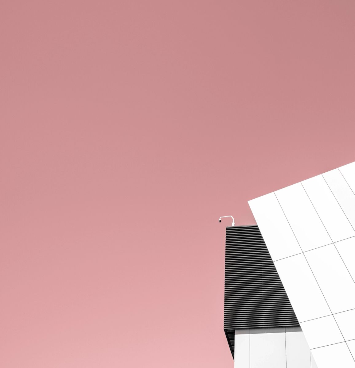 Minimalist abstract architectural photography print with a bright flamingo pink sky and contrasting white/black geometric building, titled Flamingo.